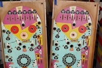 Image # 49332: Flip a Card Two Playfield Color Versions 
(The left playfield has a light beige color, while the right playfield has white, on the top 'K' rollovers worth 300 points, in the lower pop bumper circle, and in the playfield arrows that point to the targets.)
